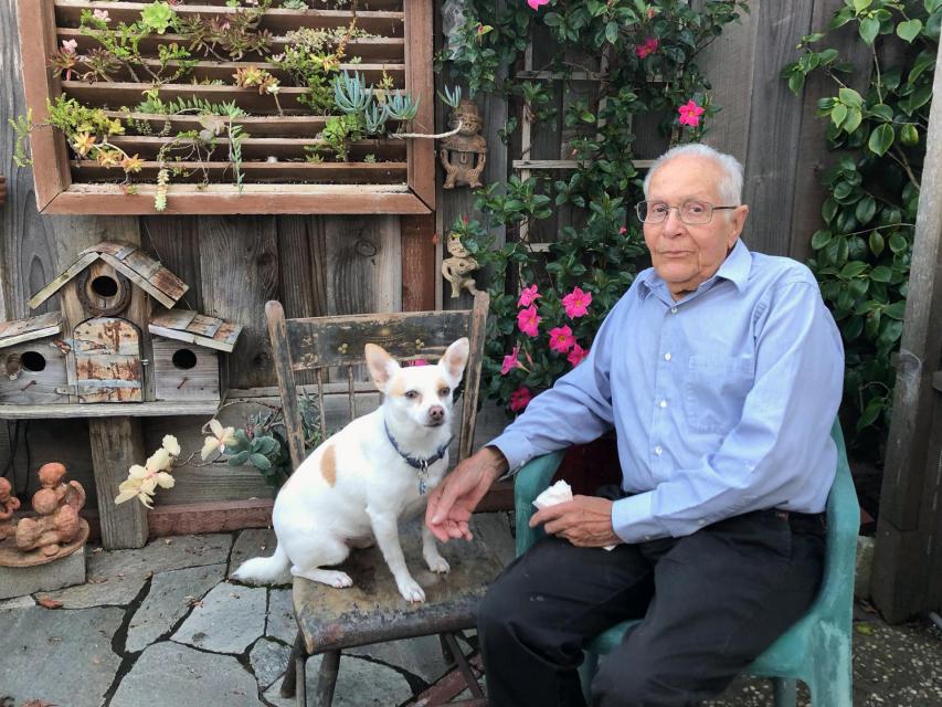 Amador Valdez with his dog Blanco in his garden