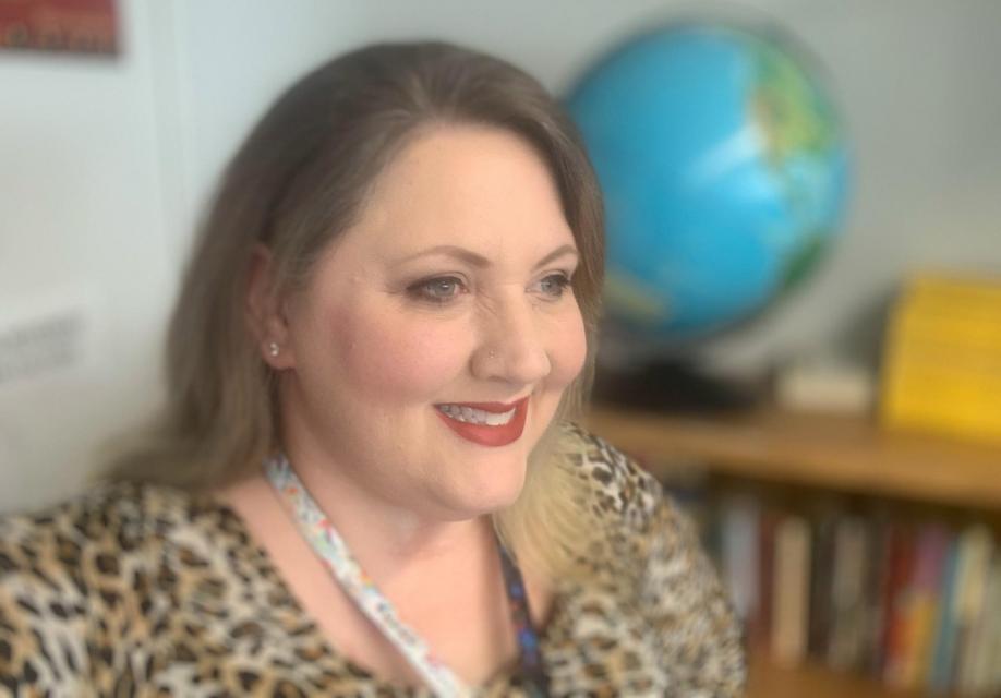 Heather Molloy in her classroom with globe behind her