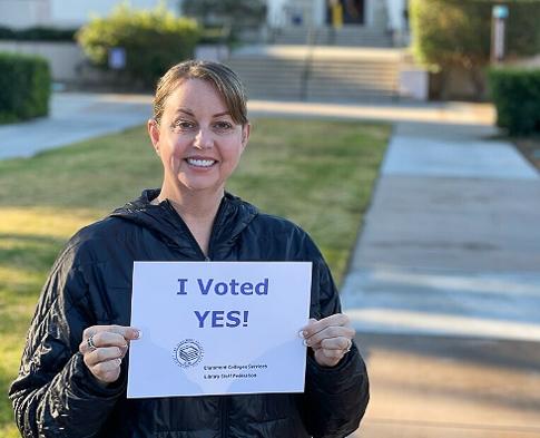 Librarian organizer Jennifer Beamer holding Yes vote sign