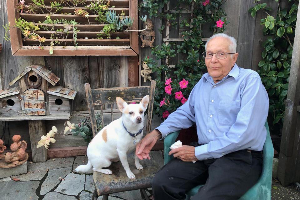 Amador Valdez with his dog Blanco in his garden