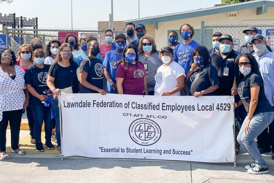 Classified employee members of the Lawndale Federation around a union banner