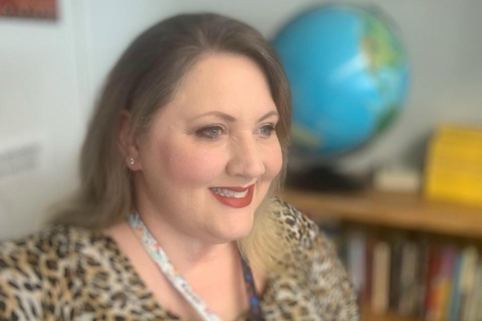 Heather Molloy in her classroom with globe behind her