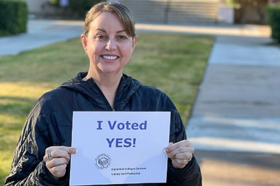 Librarian organizer Jennifer Beamer holding Yes vote sign