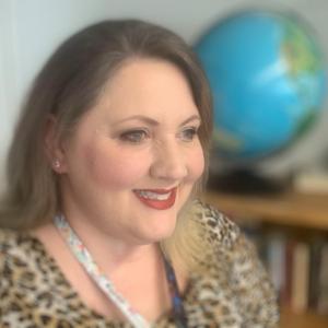 Heather Molloy in her classroom with globe behind her