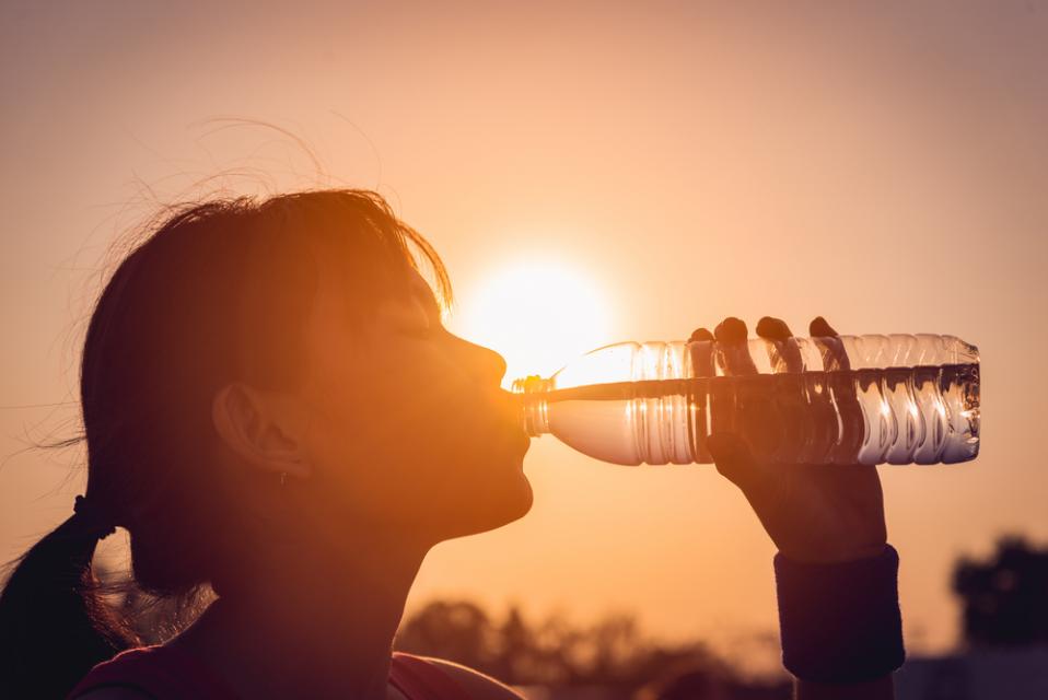 woman drinking water in extreme heat